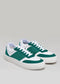 Un par de V23 Green & White low top sneakers con cordones blancos sobre fondo gris.