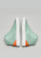 A pair of V38 Green W/ White sneakers with orange accents at the toe and white soles, displayed against a grey background.