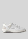 White canvas low-top sneaker with perforations and a black sole, displayed against a light gray background.
