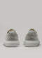 Une paire de baskets V3 Full Color Grey sneakers avec des semelles blanches, tournées vers l'extérieur, sur un fond gris.