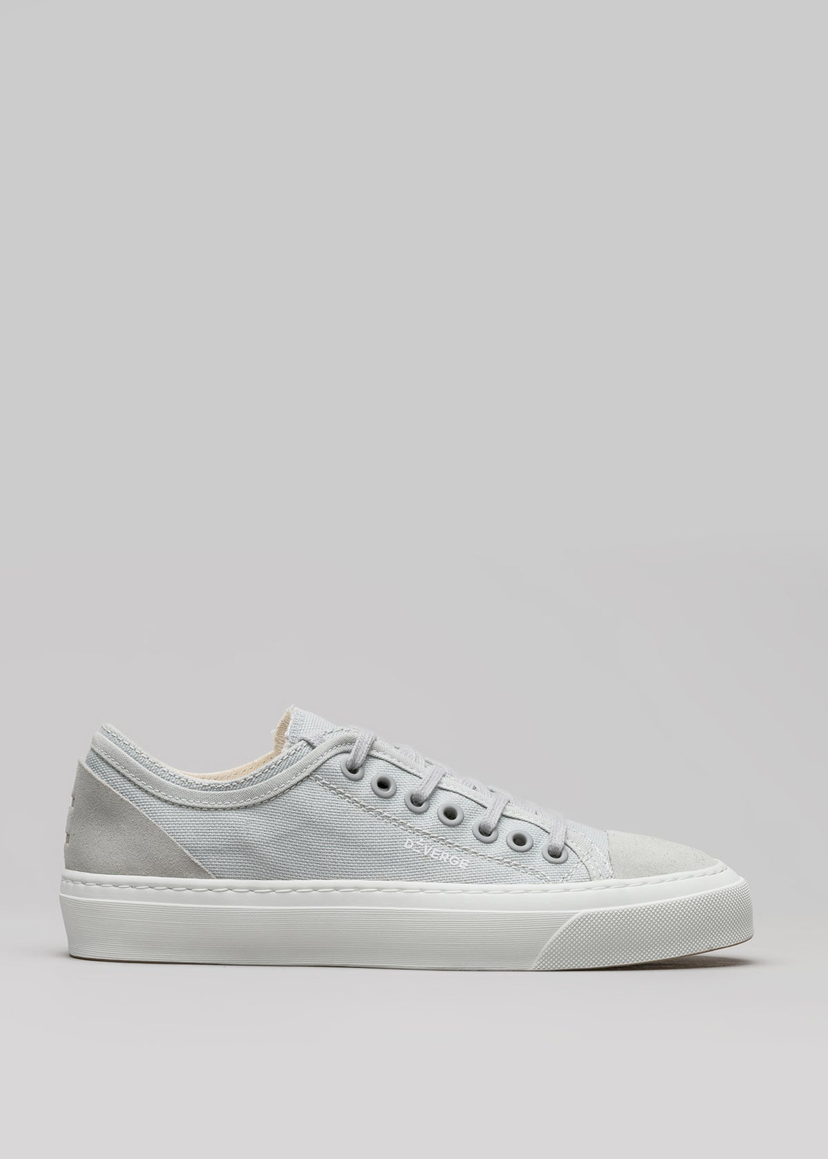 Una singola sneaker low top V3 Full Color Grey con lacci bianchi e suola in gomma bianca, su uno sfondo grigio.
