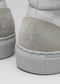 Close-up of the back heels of two V7 Grey Floater high top sneakers with textured soles and embossed "nike" logos.