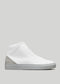 Zapatillas V39 blancas y grises de caña alta con parte superior texturizada, talonera de ante gris y suela gruesa de goma blanca sobre fondo gris claro.