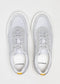 Paire de baskets V2 grises sneakers avec lacets et semelles blancs, vues de dessus sur fond uni. Marque "d'verge" visible sur les semelles intérieures.