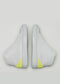Un par de MH0005 Be Your Own Star sneakers con un detalle amarillo neón en los talones, sobre un fondo gris claro.