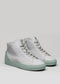 A pair of white leather high-top sneakers with V35 Grey W/ Pastel Green soles on a grey background.