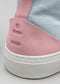 Primer plano de una zapatilla de deporte de caña alta TH0006 de Rita que muestra el parche rosa texturizado del talón con detalle del logotipo en relieve sobre una suela blanca.
