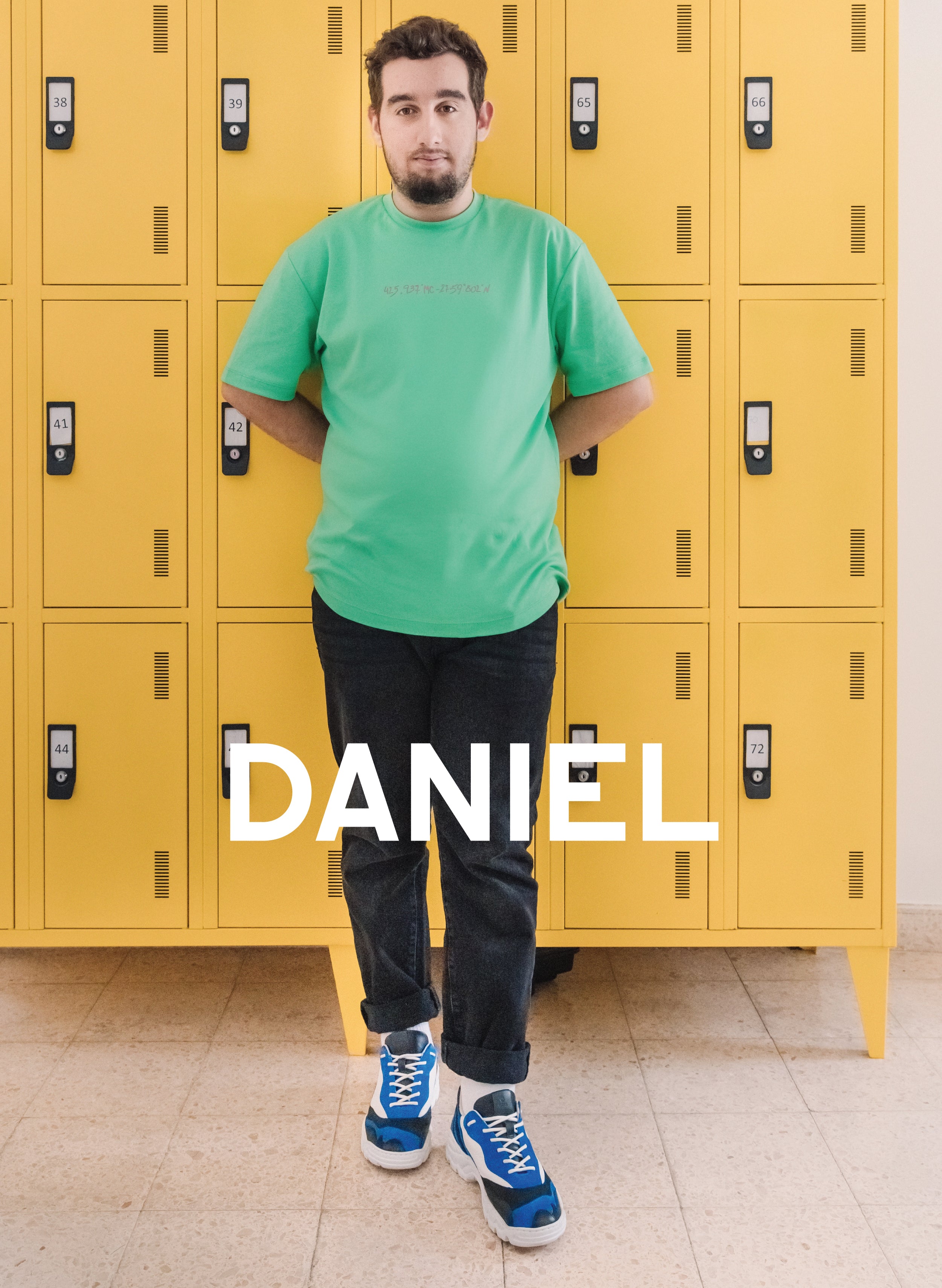 Daniel apoyado en un casillero amarillo, con Diverge sneakers, promoviendo el impacto social y el calzado personalizado a través del proyecto Imagine. 