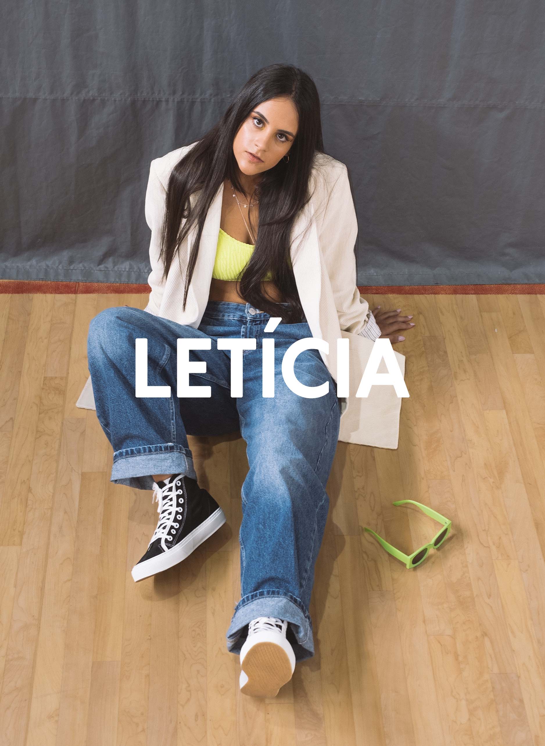 Leticia sitzt auf dem Boden eines Fitnessstudios und schaut direkt in die Kamera, Diverge sneakers, Förderung sozialer Auswirkungen und maßgefertigter Schuhe im Rahmen des IMAGINE-Projekts. 