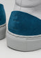 Close-up of a white high top sneaker with a textured blue heel patch bearing the embossed logo "Midnight Sky".
