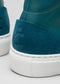 Gros plan sur les chaussures montantes V3 en cuir bleu océan sneakers avec des détails en daim et des semelles compensées blanches.
