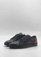 The ML0134 Deep Blue Floater W/ Caramel sneakers are meticulously crafted from premium Italian leathers, showcasing a sleek black design with dark soles and tan suede heel accents. Handcrafted in Portugal and displayed on a plain white background, they exude timeless elegance and superior craftsmanship.