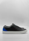 The ML0126 Black W/ Blue sneaker, crafted from premium Italian leathers and ethically made to order in Portugal, features a black leather design with a white sole and blue heel accent, showcased on a plain light background from the side view.