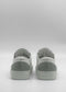 Rear view of ML0130 White W/ Grey sneakers, light green with white laces, on a plain gray backdrop, ethically made to order and showcasing exceptional craftsmanship.