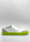 The SO0053 White W/ Yellow sneaker boasts a seamless design, neon green sole, and gray accents on the heel and toe. It's set against a plain gray background and ethically made to order from premium Italian leathers for unmatched quality.