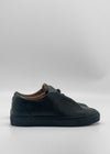 The ML0138 Black Leather sneakers are slip-ons crafted from premium Italian leather, featuring a minimalist design. Ethically made to order, these shoes are displayed against a plain white background.