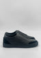 The SO0060 Black Floater sneakers, handcrafted from premium Italian leathers with a textured finish, present a sleek black slip-on design in a side view against a plain white background.