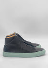 The MH0161 Black W/ Green sneakers feature high-tops with side zippers and mint green soles. Made from premium Italian leathers, they are handcrafted in Portugal and photographed on a white background, highlighting their stylish elegance and skillful craftsmanship.