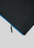 M Leather Pouch Black w/ Blue avec une fermeture éclair bleue partiellement ouverte sur fond blanc, classé dans la catégorie des articles en cuir.