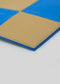 Primer plano de una alfombrilla plegable de color azul y tostado con un M Patchwork Pouch Yellow & Blue sobre fondo blanco.