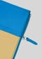 Primo piano di una vivace pochette M Patchwork Pouch Yellow & Blue con cerniera e linguetta blu su sfondo bianco.