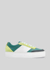 Side view of a multicolored low top sneaker N0015 by Jéssica with green, yellow, and white panels on a gray background.