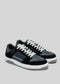 A pair of new M0001 by Fernando low top sneakers in black and white on a gray background.