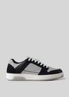The M0026 by Miguel is a black and gray retro-future sneaker with white laces and a pristine white sole, shown on a plain gray background. Handcrafted in Portugal from premium Italian leathers, it blends timeless elegance with modern innovation.