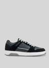 A black leather low top sneaker with white laces and a white rubber sole, featuring the M0001 by Fernando in a side profile view against a grey background.