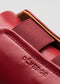Primo piano di un portafoglio in pelle V3 Red Wine con il marchio "de'verge" in rilievo, che mostra le cuciture dettagliate e la texture della pelle.