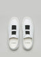 Un par de V4 Snow White Floater w/Bone slip-on sneakers con una banda elástica negra sobre un fondo gris. Cada zapatilla lleva el nombre de la marca "d'verge" en el interior.