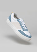 Ein stylischer Sneaker mit V11 White & Artic Blue-Paneelen, weißer Schnürung und dicker weißer Sohle vor neutralem grauem Hintergrund. Dies sind vegane Schuhe, die sowohl für Komfort als auch für Stil entworfen wurden.