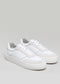 Un paio di scarpe vegane basse V3 White & Bone con lacci su sfondo grigio chiaro.