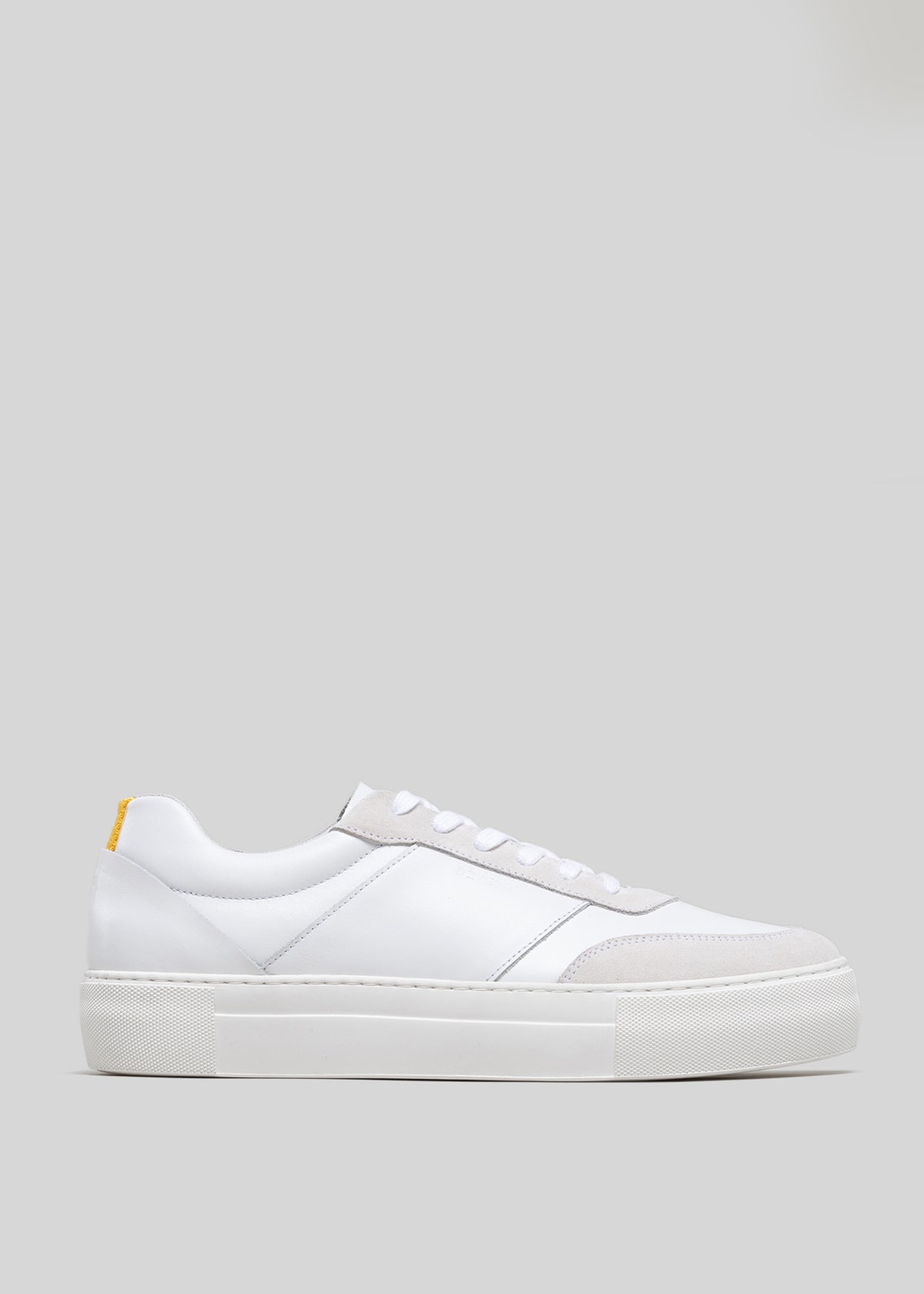 Vista laterale di una sneaker low-top V3 White & Bone con punta testurizzata e una piccola linguetta gialla sul tallone.