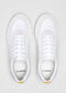 Ein Paar weißer veganer Schuhe der Marke V3 White & Bone mit grauen Akzenten, die nach unten auf einem hellgrauen Hintergrund dargestellt sind.