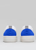 Vue arrière d'une paire de baskets V24 White & Electric Blue sneakers avec des semelles blanches et une languette métallique.