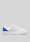 Side view of a V24 White & Electric Blue low top sneaker with textured surface and blue accent on the heel against a gray background.