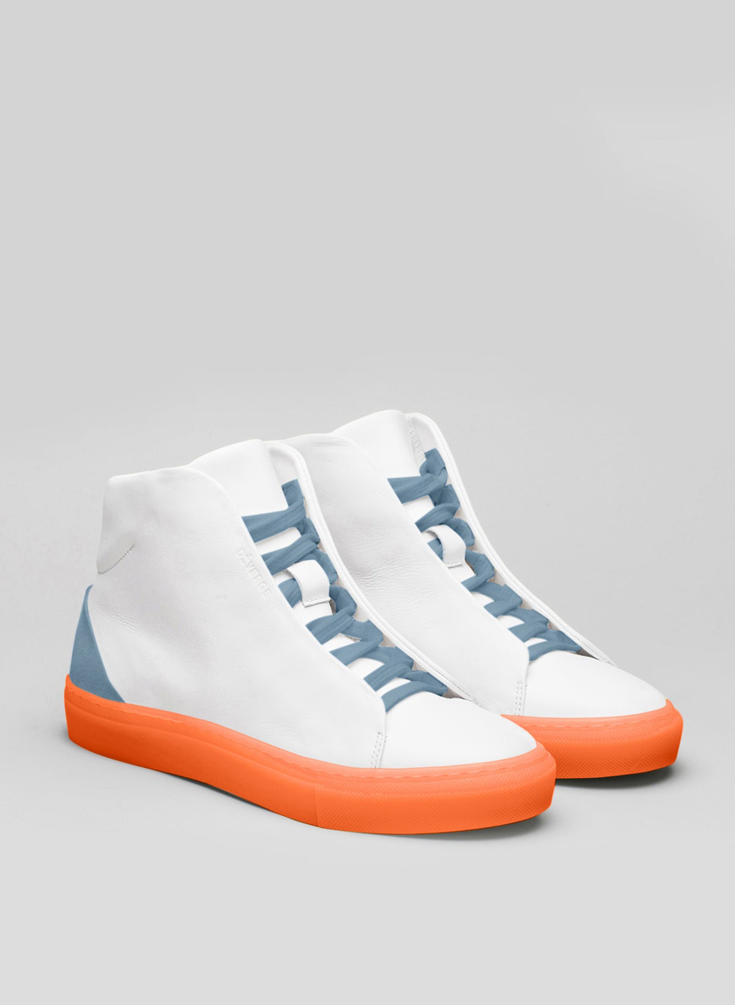 Un paio di scarpe alte bianche sneakers con lacci blu e suola arancione, in mostra le scarpe personalizzate di Diverge.