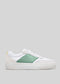 V12 White & Pastel low-top sneakers avec un panneau texturé vert, des lacets blancs et un petit détail jaune sur le talon sur un fond gris clair.
