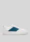 A low-profile sneaker with white upper, teal and navy panels, and a red accent on the heel. This vegan shoe features a thick white sole. V9 White & Petrol Blue