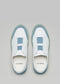 Ein Paar moderne, niedrige Slipper sneakers mit weißen und blauen Akzenten auf hellgrauem Hintergrund: V10 Weißes Leder m/Blau.