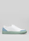 Sneaker slip-on V10 in pelle bianca e blu con suola verde menta su sfondo grigio chiaro.