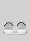 sneakers Vue arrière de deux chaussures TL0001 en daim à semelles en caoutchouc blanc, avec une bande noire et un logo sur la languette du talon, sur fond gris.