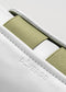 Nahaufnahme eines V11 White Leather w/Petrol Low-Top-Sneakers mit olivgrünen Akzenten und geprägtem "de-verge"-Branding auf dem Leder.