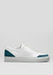 V11 White Leather w/Petrol slip-on sneaker with blue accents on the heel and toe, displayed against a light gray background.