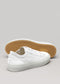 Un par de zapatillas bajas Start With a White Canvas sneakers con suela de goma, mostradas una al lado de la otra con la parte inferior de una de ellas visible, sobre un fondo gris claro.