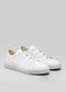 Un par de Start With a White Canvas low top de lona blanca sneakers con cordones blancos, sobre un fondo gris claro.