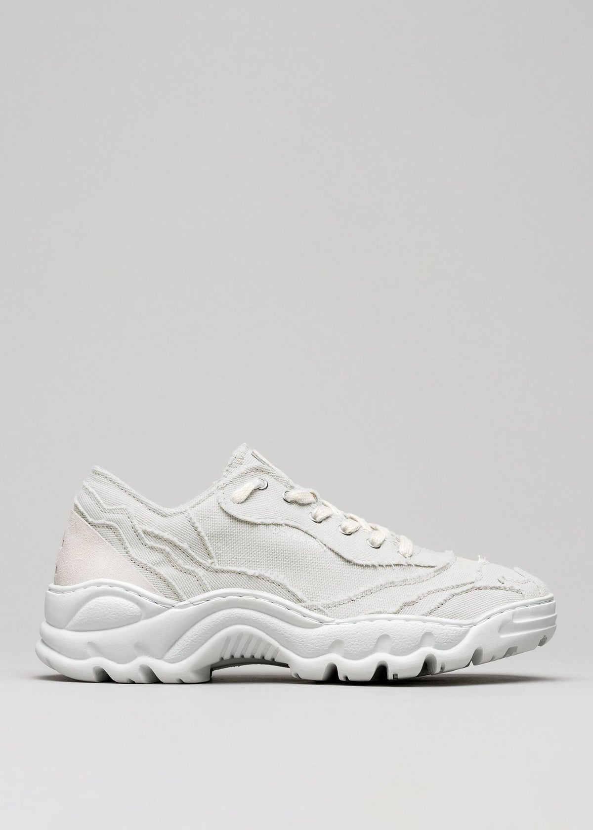 A single Landscape Canvas White athletic sneaker with chunky soles, displayed against a gray background.