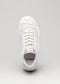 Vista dall'alto di una sneaker low top stringata bianca con il marchio "Start with a White Canvas" sulla linguetta, visualizzata su uno sfondo grigio chiaro.