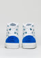 A pair of white high-top sneakers with blue suede accents and a pattern of small blue airplanes on the sides, displayed against a plain gray background. These I Just Like Birds shoes are designed to stand out in any collection.